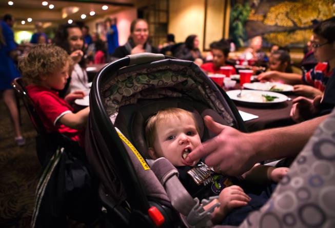 Timothy Collins Jr., 9 months old, enjoys a finger of mashed potatoes during a complimentary Thanksgiving dinner at the 24th annual Turkey Gobble at Piero's Italian Cuisine for underprivileged children and families from local nonprofit organizations on Thursday, Nov. 27, 2014.