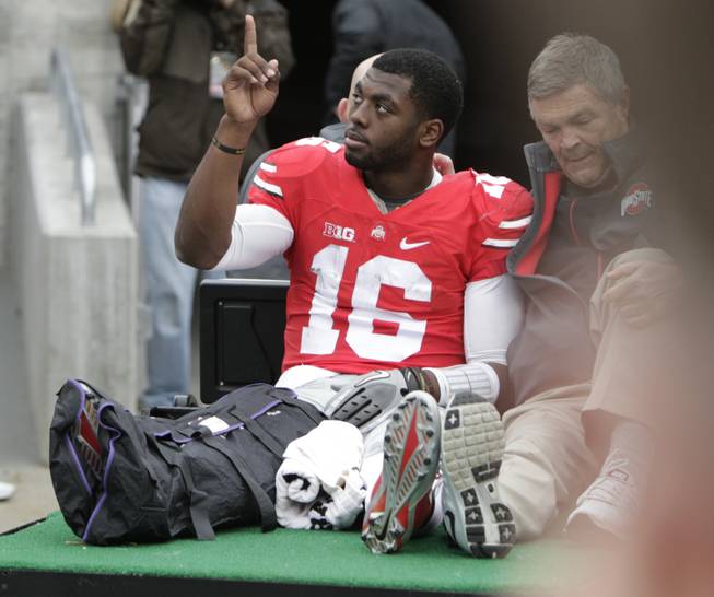 Ohio State quarterback J.T. Barrett acknowledges fans as he is driven from the field after an injury in the fourth quarter Saturday, Nov. 29, 2014, in Columbus, Ohio. Ohio State beat Michigan 42-28. 