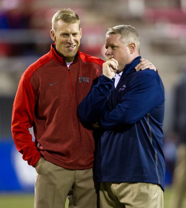 UNLV head coach Bobby Hauck and UNR head coach Brian Polian come together on the field in Sam Boyd Stadium on Friday, November 29, 2014.