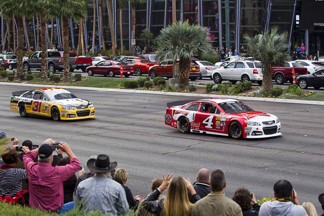 Ryan Newman, left, and Kevin Harvick head out for a NASCAR Victory Lap on the Las Vegas Strip Thursday, Dec. 4, 2014. The annual event is part of the NASCAR Champion's Week.