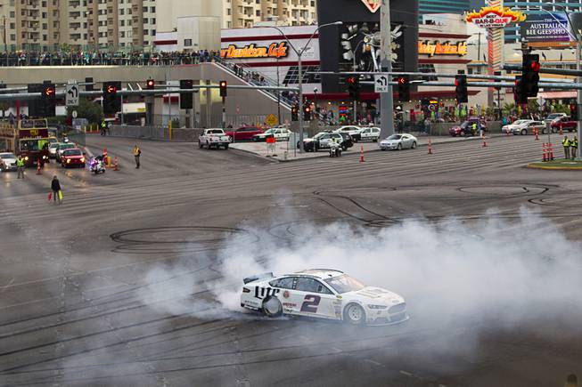 Brad Keselowski burns out at Harmon Avenue during a NASCAR Victory Lap on the Las Vegas Strip Thursday, Dec. 4, 2014. The annual event is part of the NASCAR Champion's Week.