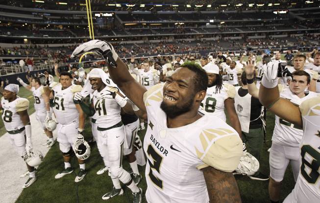 Baylor defensive end Shawn Oakman (2) waves to fans following an NCAA college football game against the Texas Tech, Saturday, Nov. 29, 2014, in Arlington, Texas. Baylor won the game 48-46.