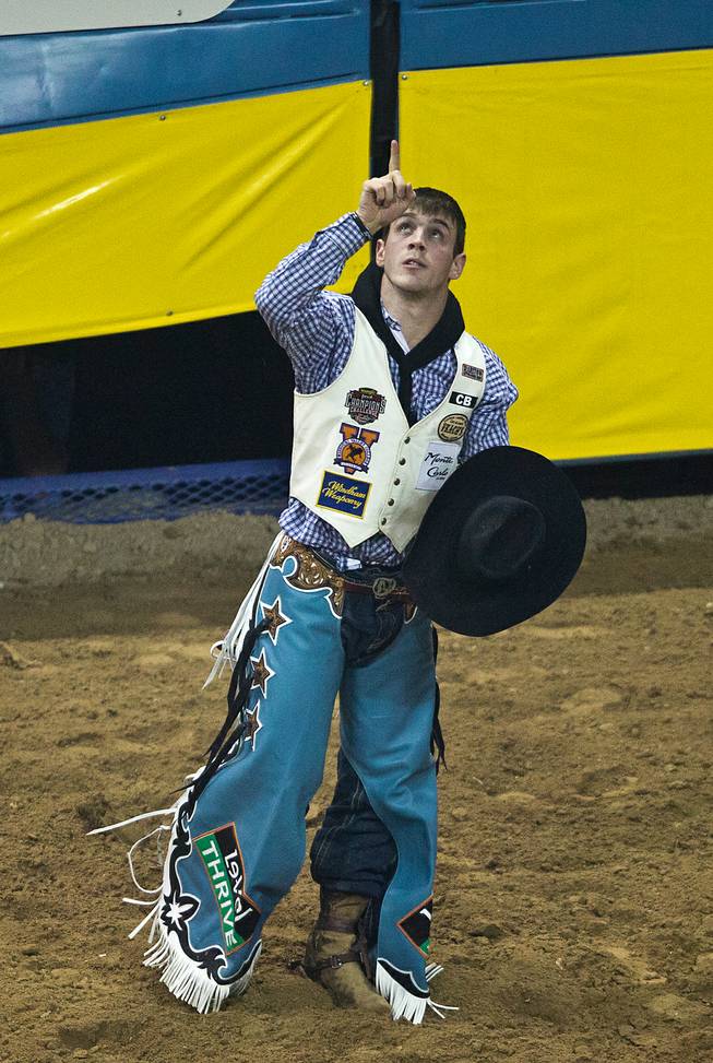 Bareback rider Tim O'Connell from Zwingle, Iowa, points to the heavens after a safe ride during the 56th Wrangler  National Finals Rodeo at the Thomas & Mack Center on Tuesday, December 9, 2014. L.E. Baskow.