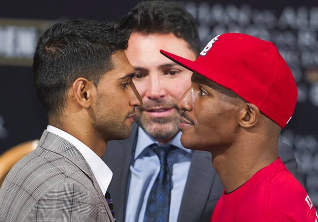 Welterweight boxers Amir Khan of Britain and Devon Alexander of St. Louis, Mo. face off during a final news conference at MGM Grand on Thursday, Dec. 11, 2014. Promoter Oscar De La Hoya is at center. Khan and Alexander will fight in a welterweight fight at MGM Grand Garden Arena on Saturday.