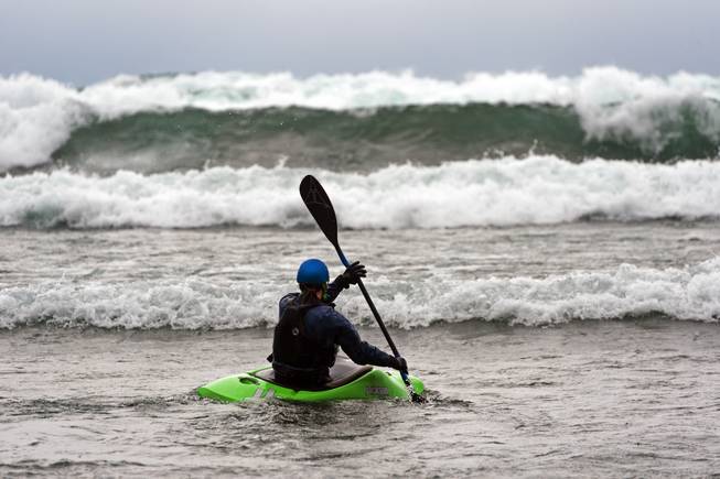In this photo provided by Scott Sady of TahoeLight.com, Jessica Yurtinis of Reno, Nev., paddles her kayak through the five- to seven-foot waves on Lake Tahoe kicked up by a strong storm moving across California and Nevada, near Incline Village, Nev., Thursday, Dec 11, 2014. Winds gusting to 140 mph whipped through Sierra Nevada mountain passes ahead of a powerful wet Pacific storm Thursday, toppling trees and damaging homes in the Lake Tahoe area and grounding commercial airline flights in Reno, authorities said. No injuries were reported from the storm that National Weather Service meteorologist Jim Wallmann said was expected to bring up to 3 feet of wet snow in higher elevations, a foot in elevations below 7,000 feet, and rain to the Reno-Sparks area. 