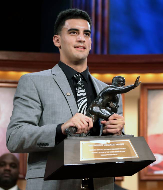 In this photo provided by the Heisman Trust, Oregon quarterback Marcus Mariota holds the Heisman Trophy after being named college football's best player during the Heisman Trophy presentation in New York on Saturday, Dec. 13, 2014. 