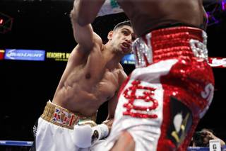 Amir Khan of Britain, left, punches at Devon Alexander of St. Louis, Mo., during a welterweight fight at the MGM Grand Garden Arena on Saturday, Dec. 13, 2014. 