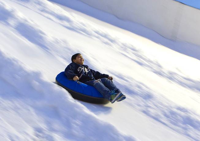 A boy heads down the Winter PARQ tubing hill in the Linq parking lot Sunday, Dec. 14, 2014. The Winter PARQ hill is open Monday through Friday from 4 p.m. to 10 p.m. and Saturday through Sunday from 2 p.m. to 10 p.m. The hill will close at 8:30 p.m. on Christmas Eve.