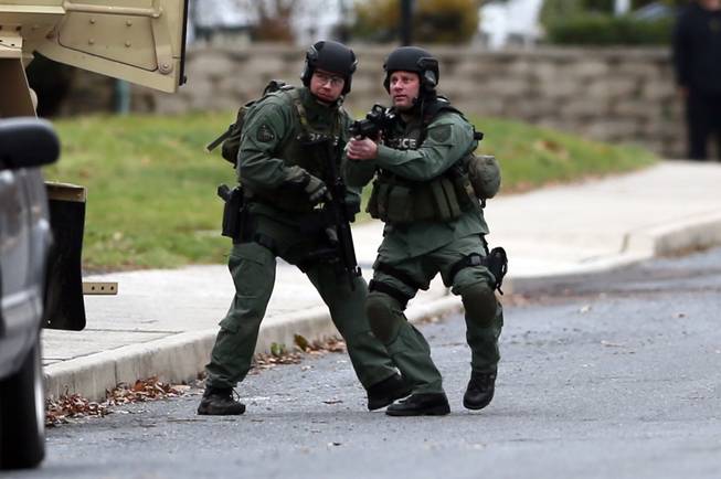Police move near the scene of a shooting Monday, Dec. 15, 2014, in Souderton, Pa. 