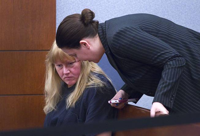 Debra Sena, left, 50, listens to attorney Caitlyn McAmis at the Regional Justice Center in Las Vegas Tuesday, Dec. 16, 2014. Along with husband Christopher Sena, 48, and his ex-wife, Terrie Sena, Debra Sena is accused of participating in sexual abuse that lasted 12 years and affected at least eight victims, some of whom are family members, according to Metro Police.