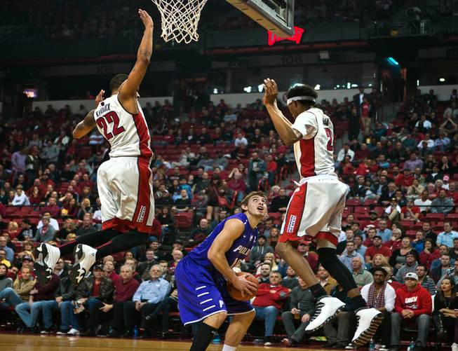 UNLV guard Jelan Kendrick (22) and teammate UNLV guard Patrick McCaw (2) leap in the air anticipating a shot by Portland guard/forward Jason Todd (10) during their game at the Thomas & Mack Center on Wednesday, December 17, 2014.