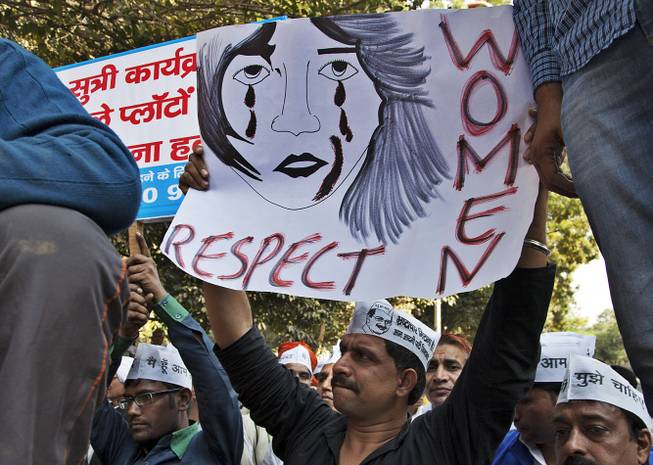 In this Dec. 8, 2014 file photo, supporters of Aam Aadmi (Common Man) Party (AAP) hold placards during a protest after a woman was allegedly raped by a driver from ride-booking service Uber in New Delhi, India. Uber promises to focus on rider safety amid increasing concerns that its drivers are not adequately screened for past criminal convictions. In a blog post Wednesday, Dec. 17, 2014, 