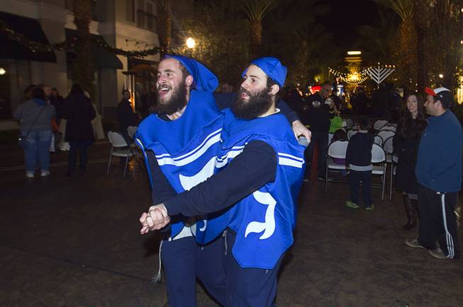 Dancing dreidels Motti Harlig, left, and Srolik Winner perform during a Hanukkah menorah lighting ceremony in The District in Henderson Thursday, Dec. 18, 2014.