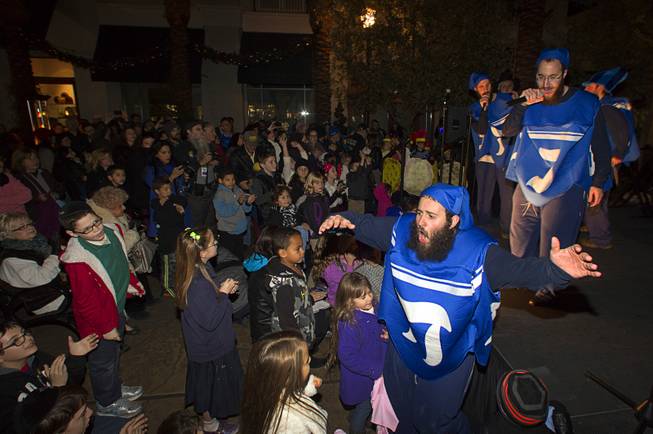 Dancing dreidel Srolik Winner, bottom, right, perform during a Hanukkah menorah lighting ceremony in The District in Henderson Thursday, Dec. 18, 2014.