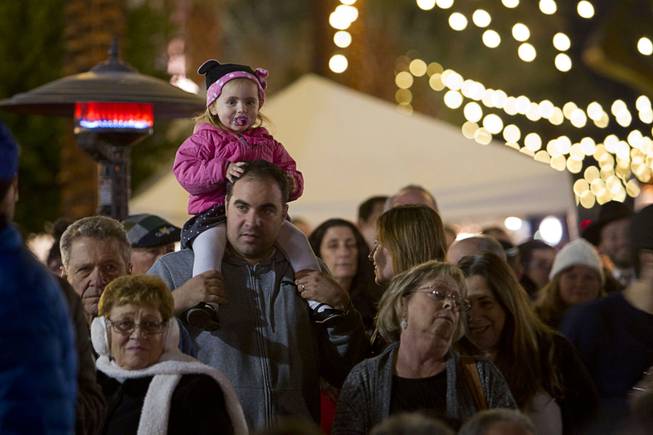 A child sits on her father's shoulder during a Hanukkah menorah lighting ceremony in The District in Henderson Thursday, Dec. 18, 2014. The event, celebrating the third night of Hanukkah, was organized by Chabad of Green Valley.