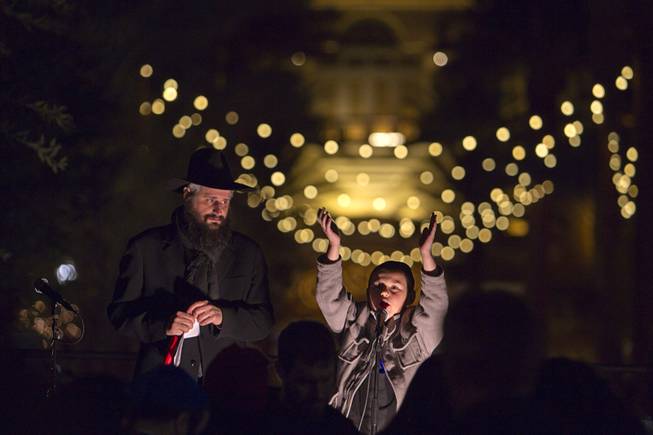 Rabbi Mendy Harlig watches his son Levi, 9, during a Hanukkah menorah lighting ceremony in The District in Henderson Thursday, Dec. 18, 2014. The event, celebrating the third night of Hanukkah, was organized by Chabad of Green Valley.