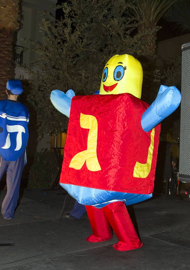 "Penny," a human dreidel, performs during a Hanukkah menorah lighting ceremony in The District in Henderson Thursday, Dec. 18, 2014. The event, celebrating the third night of Hanukkah, was organized by Chabad of Green Valley.