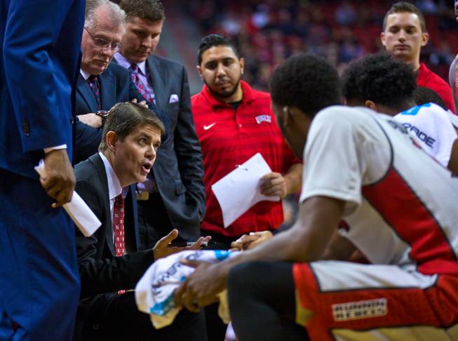 UNLV head coach Dave Rice works closely with his players during a late-game timeout versus Portland at the Thomas & Mack Center on Wednesday, December 17, 2014.