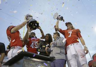 Utah quarterback Travis Wilson, right, and other players celebrate after they defeated Colorado State in the Las Vegas Bowl NCAA college football game Saturday, Dec. 20, 2014, in Las Vegas. Utah won 45-10. (AP Photo/John Locher)