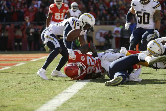 Kansas City Chiefs wide receiver Dwayne Bowe, center, fumbles the ball against San Diego Chargers cornerback Brandon Flowers, left, and San Diego Chargers defensive back Jahleel Addae during the first half of an NFL football game in Kansas City, Mo., on Sunday, Dec. 28, 2014. The ball was recovered for a touchdown by Kansas City Chiefs tight end Travis Kelce.