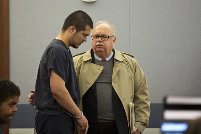 Jin William Ackerman speaks with his defense attorney Tom Pitaro during Ackerman's 72-hour hearing at the Regional Justice Center, Las Vegas, Wed. Dec 31, 2014. Ackerman is accused of robbing a Las Vegas Walgreens and shooting and killing the store clerk, which whom he had known personally.