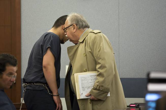 Jin William Ackerman speaks with his defense attorney Tom Pitaro during Ackerman's 72-hour hearing at the Regional Justice Center, Las Vegas, Wed. Dec 31, 2014. Ackerman is accused of robbing a Las Vegas Walgreens and shooting and killing the store clerk, which whom he had known personally.