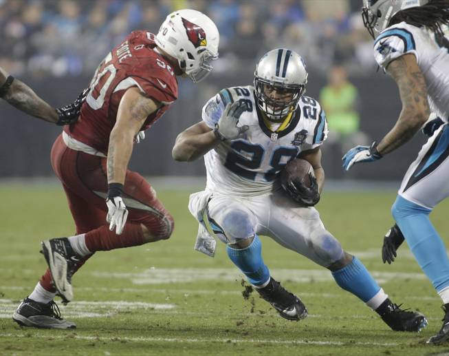 Carolina Panthers running back Jonathan Stewart tries to avoid Arizona Cardinals linebacker Larry Foote in the second half of an NFL wild card playoff football game in Charlotte, N.C., Saturday, Jan. 3, 2015.