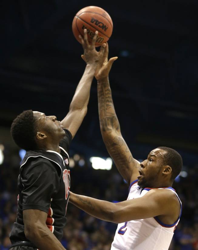 UNLV forward Goodluck Okonoboh, left, blocks a shot by Kansas forward Cliff Alexander during the first half of an NCAA college basketball game in Lawrence, Kan., on Sunday, Jan. 4, 2015.