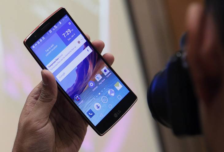A man photographs the LG G Flex 2 during a media preview before CES International Sunday, Jan. 4, 2015, in Las Vegas. The phone has a curved screen, as the name implies.