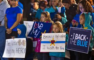 Kids hold handmade signs as hundreds gather at Police Memorial Park attending a Sea of Blue rally to show support for police everywhere on Friday, January 9, 2015. .