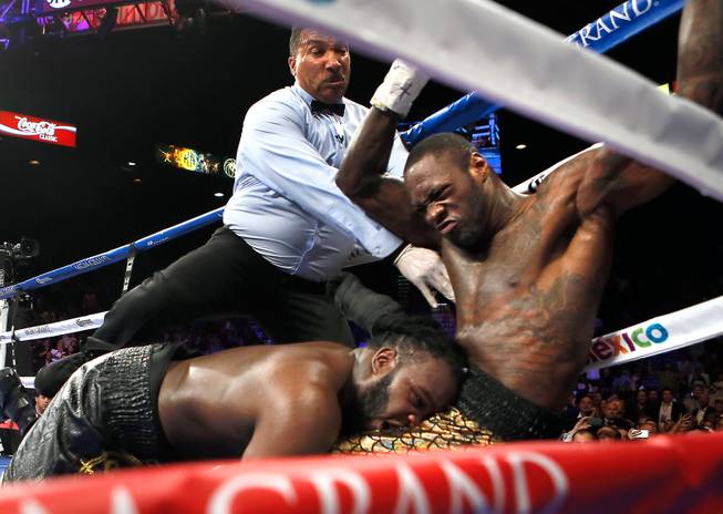 Bermane Stiverne falls into the lap of Deontay Wilder as the two stumbled during their WBC Heavyweight fight at the MGM Grand Garden Arena on Saturday, January 17, 2015.