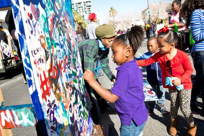 Children paint on Human Experience's mobile canvas during the 33rd Annual Dr. Martin Luther King Jr. Parade in downtown Las Vegas, Monday Jan. 19, 2015.