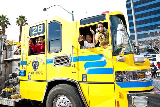 Children wave from a Clark County Fire Truck during the 33rd Annual Dr. Martin Luther King Jr. Parade in downtown Las Vegas, Monday Jan. 19, 2015.