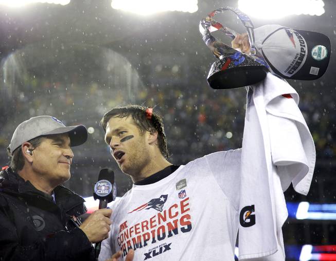 New England Patriots quarterback Tom Brady holds the championship trophy after the AFC title game Sunday, Jan. 18, 2015, in Foxborough, Mass. 