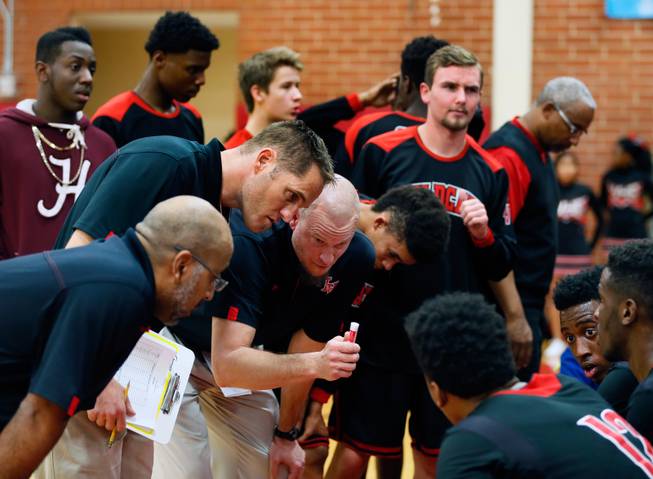 Las Vegas High head coach Jason Wilson huddles with his players in a timeout during their rivals basketball game on Tuesday, January 20, 2015.