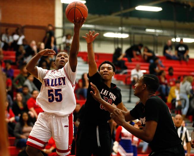 Valley High player Darrion Daniels (55) gets off a lay up shot over Las Vegas High player Tyler Bey (30) and teammate during their rivals basketball game on Tuesday, January 20, 2015.