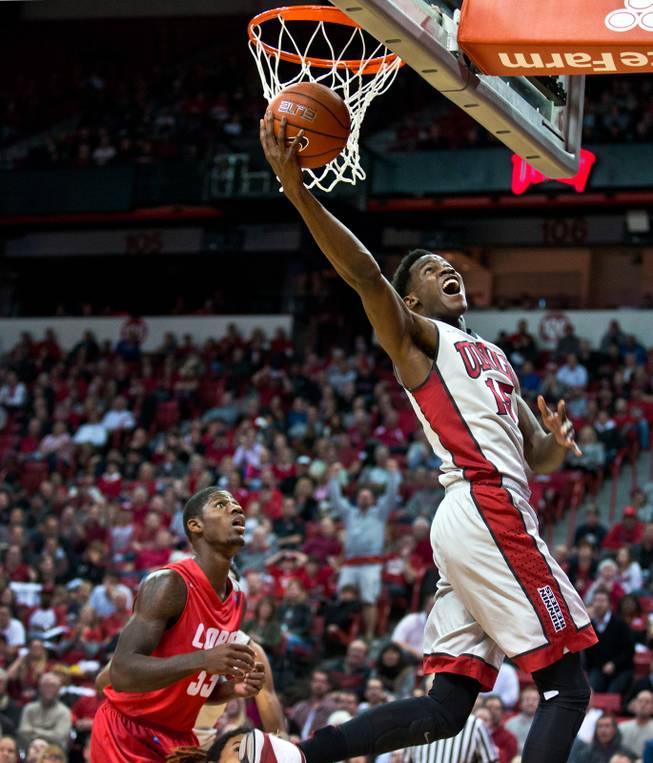 UNLV forward Dwayne Morgan (15) goes up strong to the hoop being trailed by New Mexico guard Deshawn Delaney (33) during their game at the Thomas & Mack Center on Wednesday, January 21, 2015.