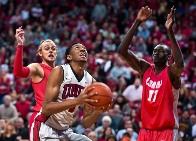 UNLV forward Christian Wood (5) looks to go up strong between New Mexico guard Hugh Greenwood (3) and New Mexico center Obij Aget (11) during their game at the Thomas & Mack Center on Wednesday, January 21, 2015.