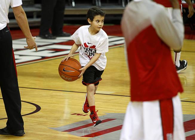 Nikolas Rymer, 9, helps shag balls as the UNLV Rebels warm up for their game against Utah State at the Thomas & Mack Center on Saturday, Jan. 24, 2015. 