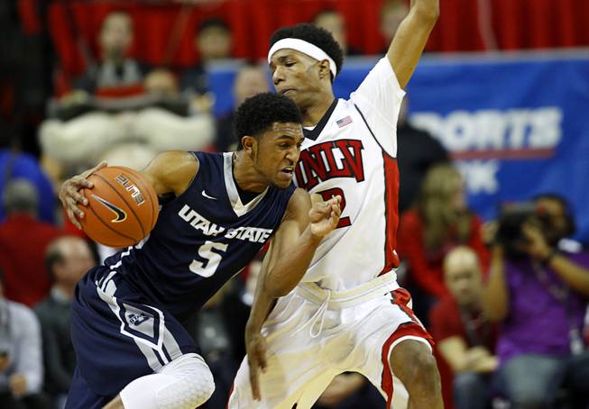 Utah State guard Julion Pearre (5) is covered by UNLV guard Patrick McCaw (2) during their game at the Thomas & Mack Center Saturday, Jan. 24, 2015.