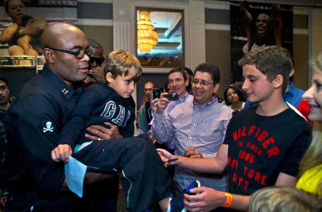 Featured UFC183 fighter Anderson Silva passes a child fan back over the barrier while taking pictures and signing autographs during media day events at the MGM Grand on Thursday, January 29, 2015.