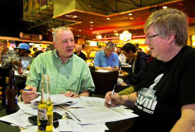 Friends Jim Zabrowski of Minneapolis and Bob Rowe of Des Moines confer on their Superbowl sports bets at the Westgate Las Vegas Resort & Casino on Saturday, January 31, 2015. The two try and come every year for the game and have hopes this one will be closer than last years.