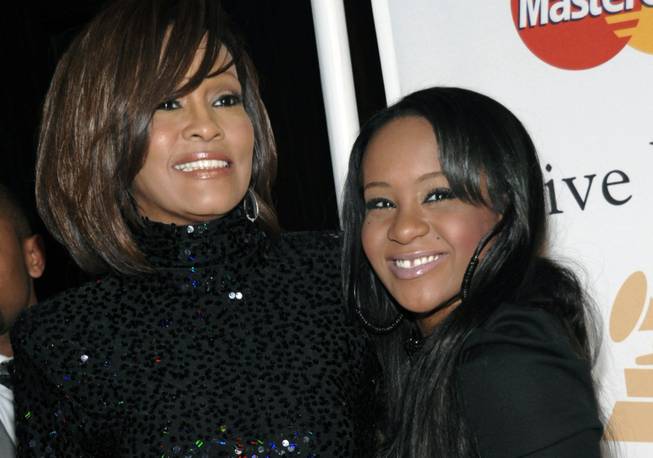 In this Feb. 12, 2011, file photo, singer Whitney Houston and daughter Bobbi Kristina Brown arrive at an event in Beverly Hills, Calif. Brown was found Saturday, Jan. 31, 2015, unresponsive in a bathtub by her husband and a friend and taken to an Atlanta-area hospital.