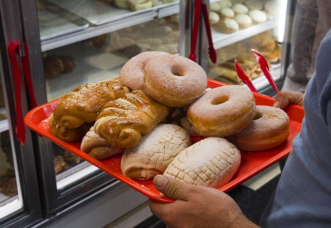 A shopper loads a tray with Mexican pastry and doughnuts at Los Compadres #4, a family-owned market, on East Tropicana Avenue Wednesday, Feb. 4, 2015. A Cardenas supermarket opened across the street from the market in in Nov. 2014.