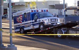 A MedicWest ambulance is loaded on a tow truck after a fatal accident involving the ambulance and two people on scooter at  Fremont Street/Boulder Highway and Sahara Avenue Monday, Feb. 9, 2015. The male driver of the scooter was killed, police said.