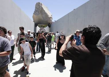 Visitors view Michael Heizer’s “Levitated Mass”  at the Los Angeles County Museum of Art in Los Angeles, on Sunday June 24,2012.  Thousands showed up as the gigantic work was unveiled on the museum’s rear lawn, where it is intended to remain forever.  