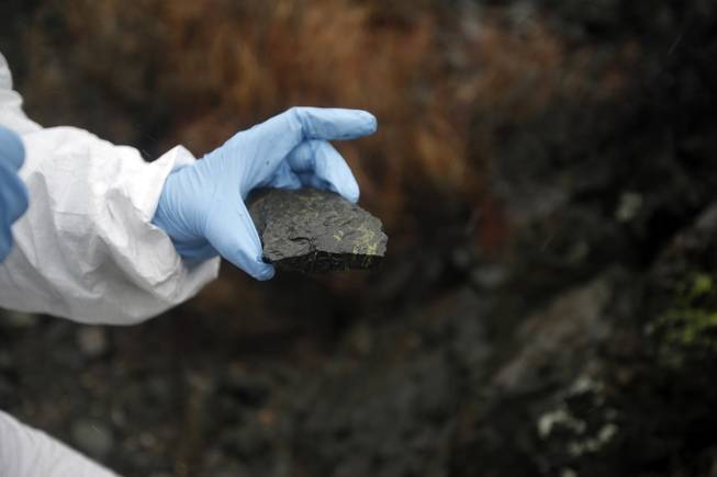 Brenda Buck, a geologist, examines a rock sample in the desert, near Henderson, Nev., Jan. 30, 2015. Research indicating a natural asbestos hazard in the air has been played down and hindered by the state of Nevada, scientists say.