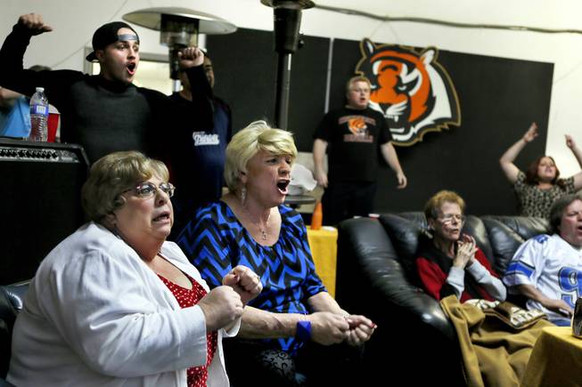 Toni and Holly Nesmith with others react to a late-game catch in the NFL Super Bowl at the Just You beauty boutique on Sunday, Feb. 1, 2015. Owner/stylist Amy Hoaeae likes to open up the shop occasionally for gatherings of friends, customers and family. 