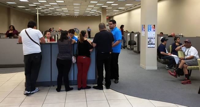 People wanting assistance to sign up for government-subsidized health insurance wait their turn Sunday morning inside the Enrollment Store at Boulevard mall.