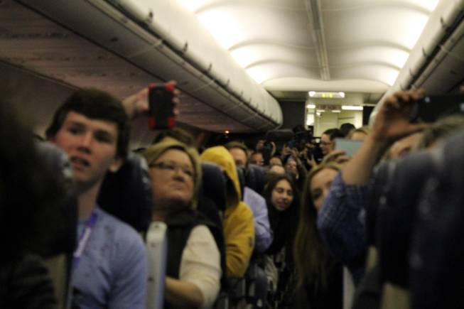 A cabin full of regular passengers and 40 contest winners watch a "Destination Dragons" in-flight performance on Tuesday, Feb. 24, 2015.